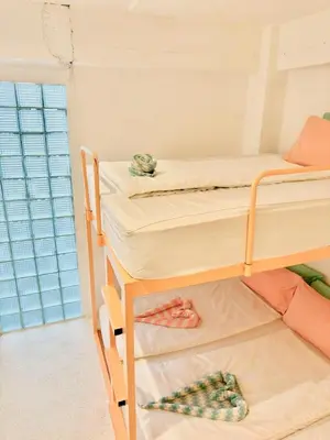 two bunk beds in a room with a window at Lazy Sunday Khaosan Hotel in Bangkok