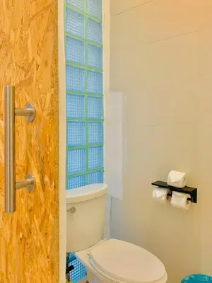 a bathroom with a toilet and a window at Lazy Sunday Khaosan Hotel in Bangkok