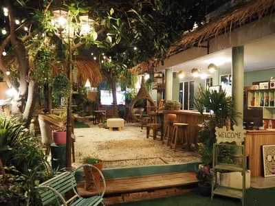 a restaurant with a lot of plants and tables at The oasis on 8 Villa pool table & KTV in Bangkok