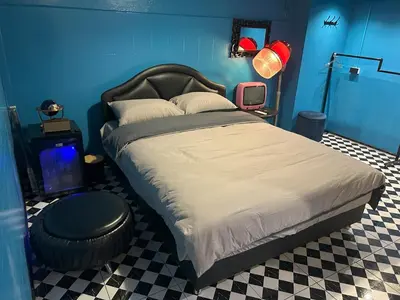 a bedroom with a large bed with a blue wall at The oasis on 8 Villa pool table & KTV in Bangkok