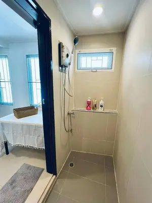 a bathroom with a shower with a bed in the background at \u66fc\u8c37\u5510\u4eba\u8857\u4e09\u5c42\u72ec\u680b\u6d0b\u697c24\u5c0f\u65f6\u81ea\u52a9\u5165\u4f4f in Bangkok