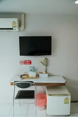 a desk with a chair and a television on a wall at Full Stop Pool Villa Don Mueang in Lak Si