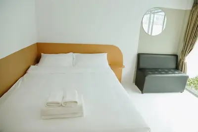 a bedroom with a bed and a black chair at Full Stop Pool Villa Don Mueang in Lak Si