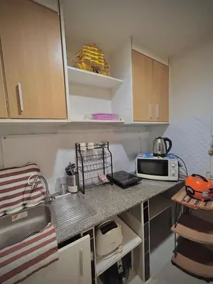 a small kitchen with a sink and a microwave at Stylish Bangkok Condo Furnished, Pool View Prime Location in Bangkok