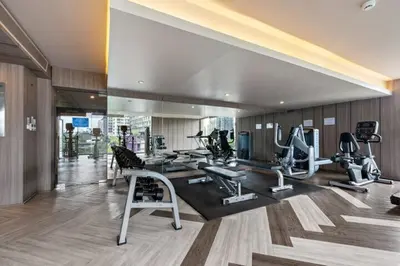a gym with several treadmills and machines in a room at BTS Thong Lor Downtown Low-rise Large 1 Bedroom in Bangkok