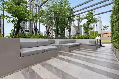 a patio with benches and trees in a building at BTS Thong Lor Downtown Low-rise Large 1 Bedroom in Bangkok