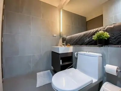 a bathroom with a white toilet and a sink at Upscale High-Rise 1BR - Ultra Fast Wifi - Phrom Phong in Bangkok