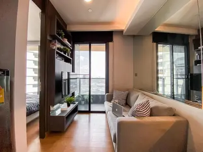 a living room with a couch and a laptop at Upscale High-Rise 1BR - Ultra Fast Wifi - Phrom Phong in Bangkok