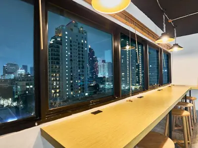 a bar with a view of a city skyline at Kinboshi Hostel Silom in Bangkok