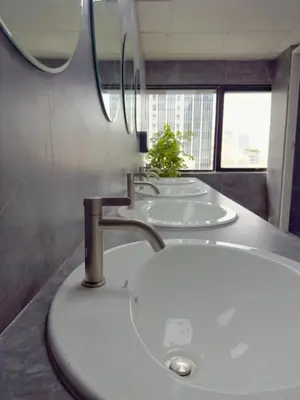 a row of three sinks in a bathroom at Kinboshi Hostel Silom in Bangkok