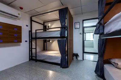 a room with three bunk beds and a mirror at Kinboshi Hostel Silom in Bangkok