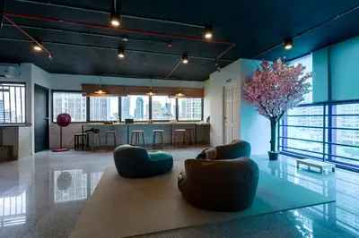 a living room with a table and chairs and a kitchen at Kinboshi Hostel Silom in Bangkok