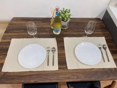 a wooden table with two white plates and two wine glasses at Modern 59m Sukhumvit 1BR - 31st Floor Pool - Gym in Makkasan