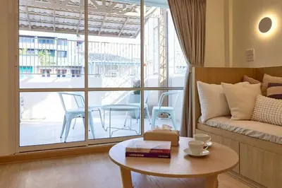 a living room with a couch and a table with books at Slaap36 5BR Home with Parking, Walk to BTS Ari in Bangkok