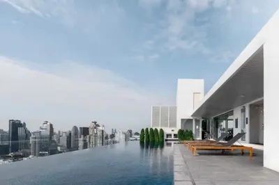a swimming pool on the roof of a building with a city at 5 Star Centric 1BD Apartment Sukhumvit in Bangkok