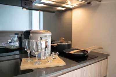 a kitchen with wine glasses on a counter at 5 Star Centric 1BD Apartment Sukhumvit in Bangkok