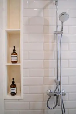 a shower in a bathroom with white tiles at 5 Star Centric 1BD Apartment Sukhumvit in Bangkok
