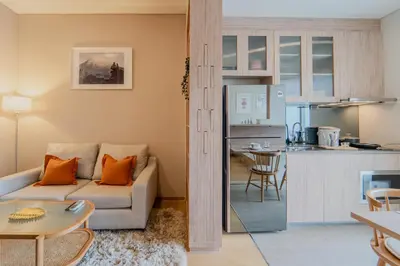 a living room with a couch and a kitchen at 5 Star Centric 1BD Apartment Sukhumvit in Bangkok
