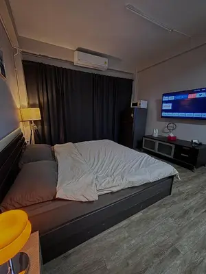 a hotel room with a bed and a television at Mango Rooms & Rooftop in Bangkok