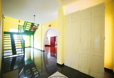 a hallway with a white door and a staircase at The Myth - Sud Sathorn in Bangkok
