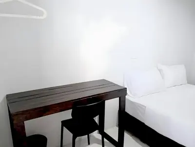 a desk with a chair next to a bed at Mitr Inn Khaosan Road - มิตรอินน์ ถนน ข้าวสาร in Bangkok