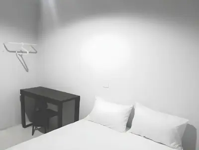 a white bedroom with a bed and a desk at Mitr Inn Khaosan Road - มิตรอินน์ ถนน ข้าวสาร in Bangkok