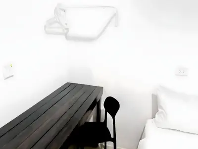 a bedroom with a wooden table next to a bed at Mitr Inn Khaosan Road - มิตรอินน์ ถนน ข้าวสาร in Bangkok