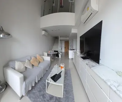 a living room with a white couch and a television at City View Luxury Condo, AirportMRT link 50 meters in Bangkok