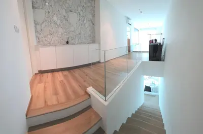 a hallway with white walls and wood floors and a glass staircase at City View Luxury Condo, AirportMRT link 50 meters in Bangkok