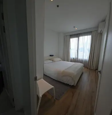 a bedroom with a white bed and a window at City View Luxury Condo, AirportMRT link 50 meters in Bangkok
