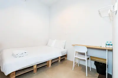 a bed in a room with a desk and a chair at XX The Hidden Khaosan Rambutri - เดอะ ฮิดเดน ข้าวสาร รามบุตรี xPro in Bangkok