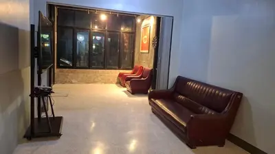 a living room with a leather couch and two chairs at The Loft House Muangthong in Ban Bang Phang