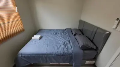 a bed with a blue comforter in a bedroom at The Loft House Muangthong in Ban Bang Phang