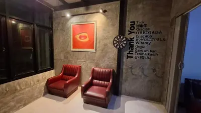 two red chairs in a room with a wall at The Loft House Muangthong in Ban Bang Phang