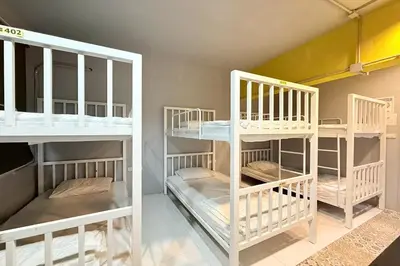 two sets of bunk beds in a room at Sukhum Huai Khwang Guest House in Bangkok