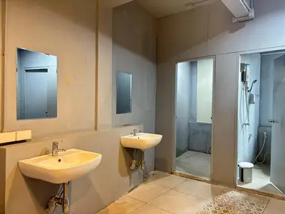 a bathroom with two sinks and a shower at Sukhum Huai Khwang Guest House in Bangkok