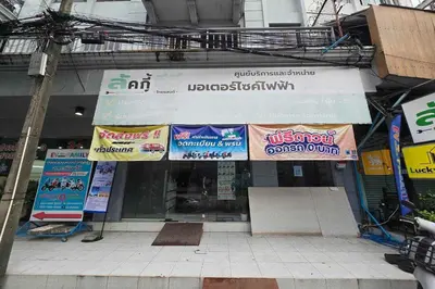 a store with signs on the front of a building at Sukhum Huai Khwang Guest House in Bangkok