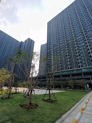 two tall buildings with trees in a park with a bridge at Life city 1 in Bang Chak