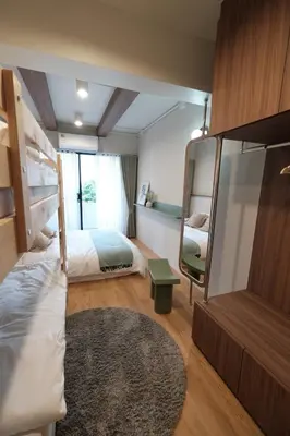 a bedroom with two bunk beds and a mirror at The Shantipan Lotus - Cozy 2BR Family Stay 400m from BTS Station in Bangkok