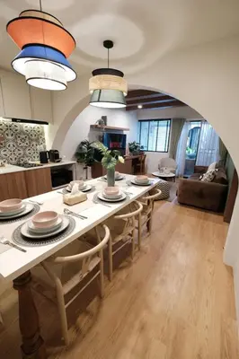 a kitchen and living room with a table and chairs at The Shantipan Lotus - Cozy 2BR Family Stay 400m from BTS Station in Bangkok