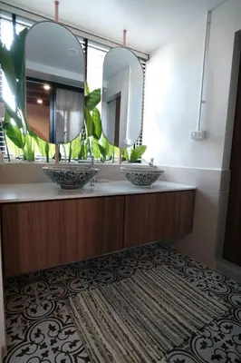 a bathroom with two sinks and two mirrors at The Shantipan Lotus - Cozy 2BR Family Stay 400m from BTS Station in Bangkok