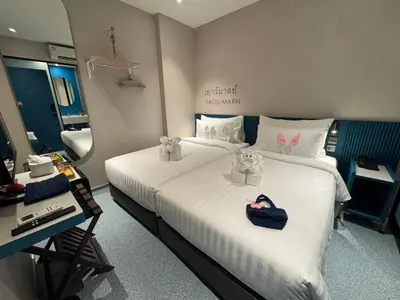 a hotel room with a large bed with two bags on it at ARNI HER Ladies Hotel - Female Only in Bangkok
