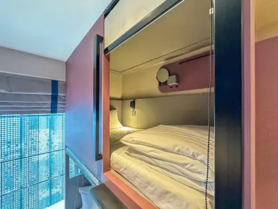 a bunk bed in a room with a balcony at ARNI HER Ladies Hotel - Female Only in Bangkok