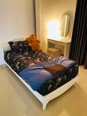 a teddy bear sitting on a bed in a bedroom at Cozy Nest Near Downtown in Bangkok