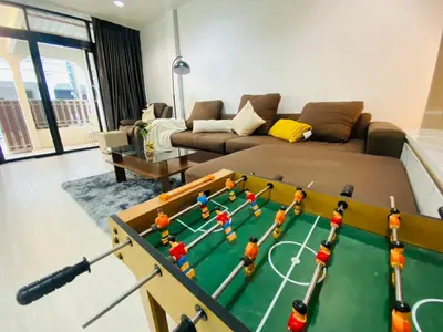 a living room with a table with a soccer game on it at Cozy Nest Near Downtown in Bangkok