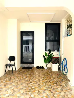 a front porch with a black door and a tile floor at Cozy Nest Near Downtown in Bangkok