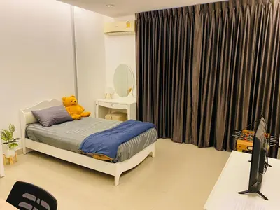 a teddy bear sitting on a bed in a bedroom at Cozy Nest Near Downtown in Bangkok