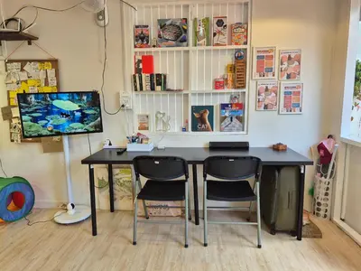 a desk with two chairs and a television in a room at Cat House BKK in Bangkok