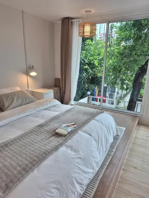 a bedroom with a bed and a large window at Cat House BKK in Bangkok
