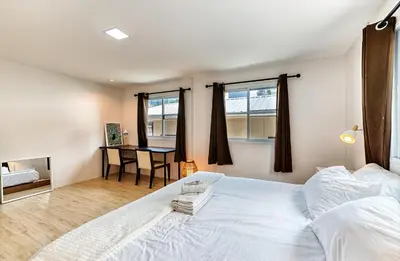 a bedroom with a large white bed and a table at Cat House BKK in Bangkok